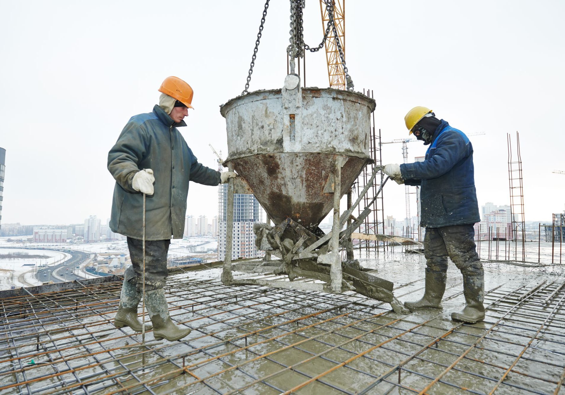 construction building workers at construction site pouring concrete in form